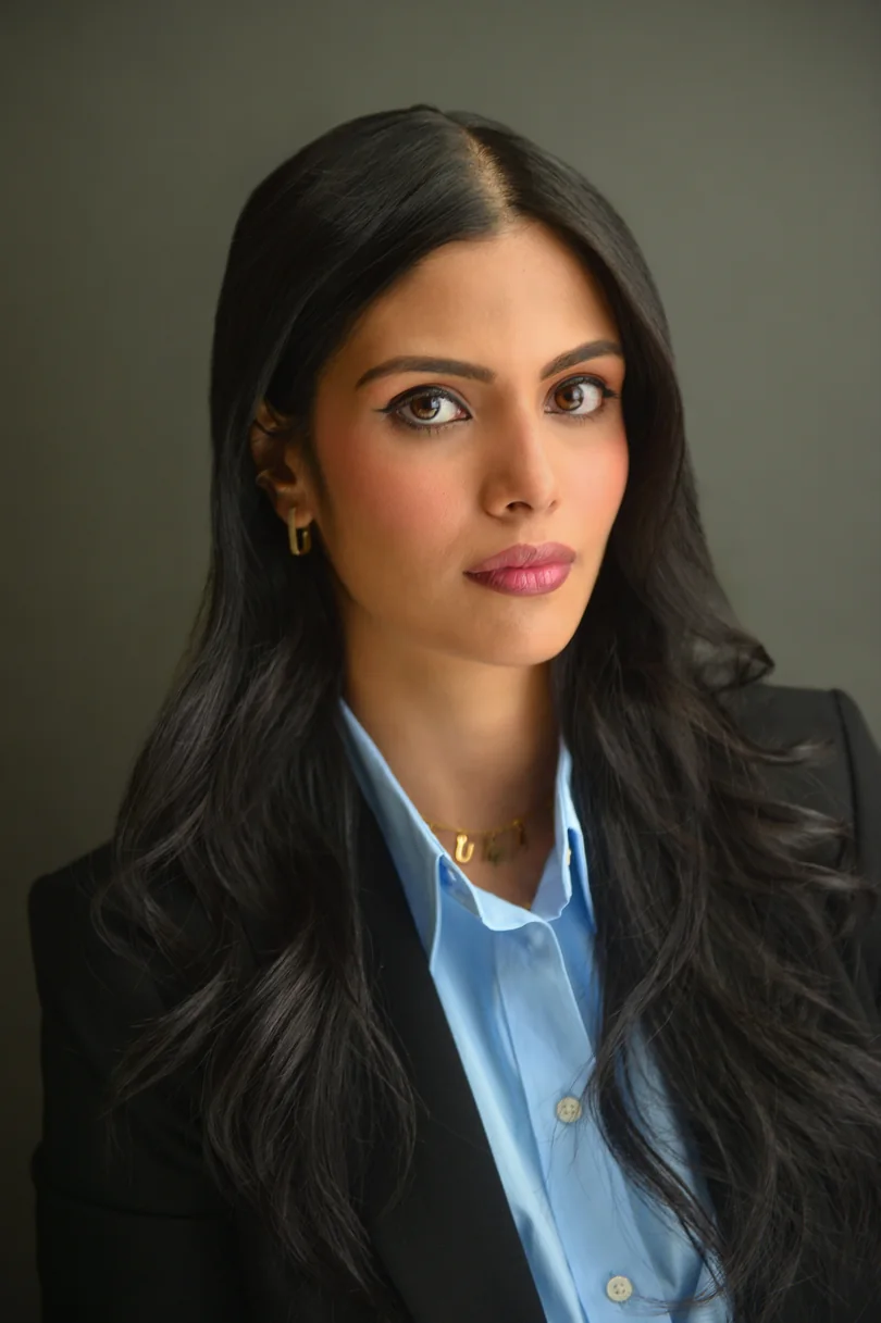 Editorial professional headshot in a black blazer and blue shirt