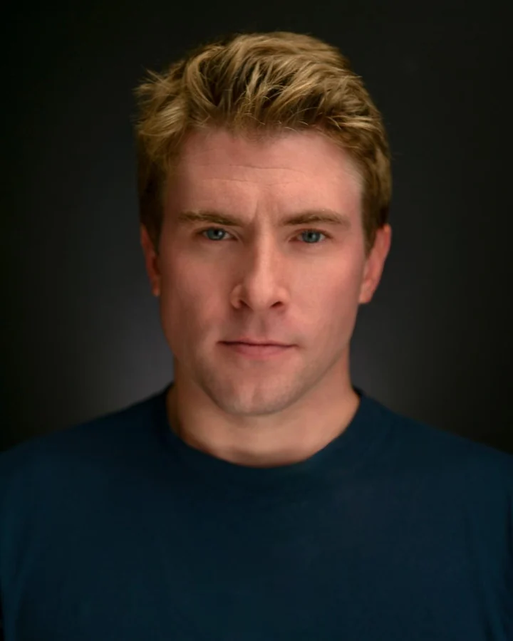 Actor headshot in a dark shirt with dramatic studio lighting