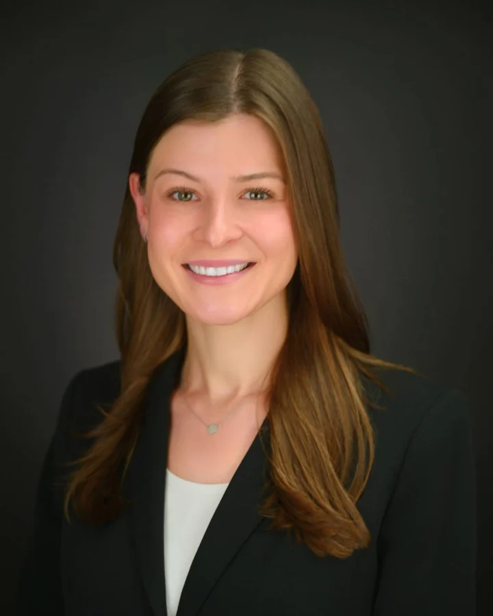 Professional headshot in a black blazer with warm studio lighting