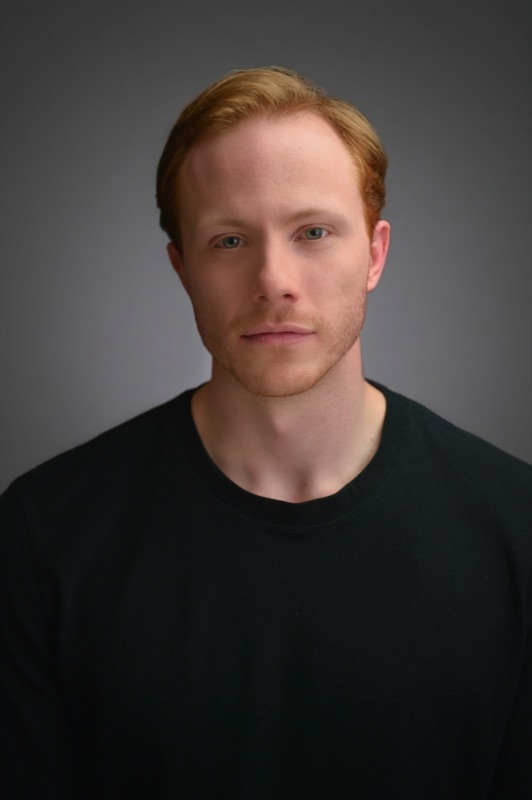 A contemporary business headshot with a warm background